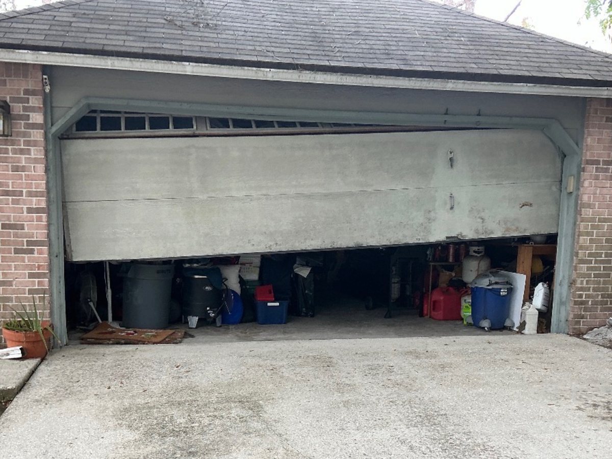 Technician replacing a broken torsion spring on a residential garage door in South Florida